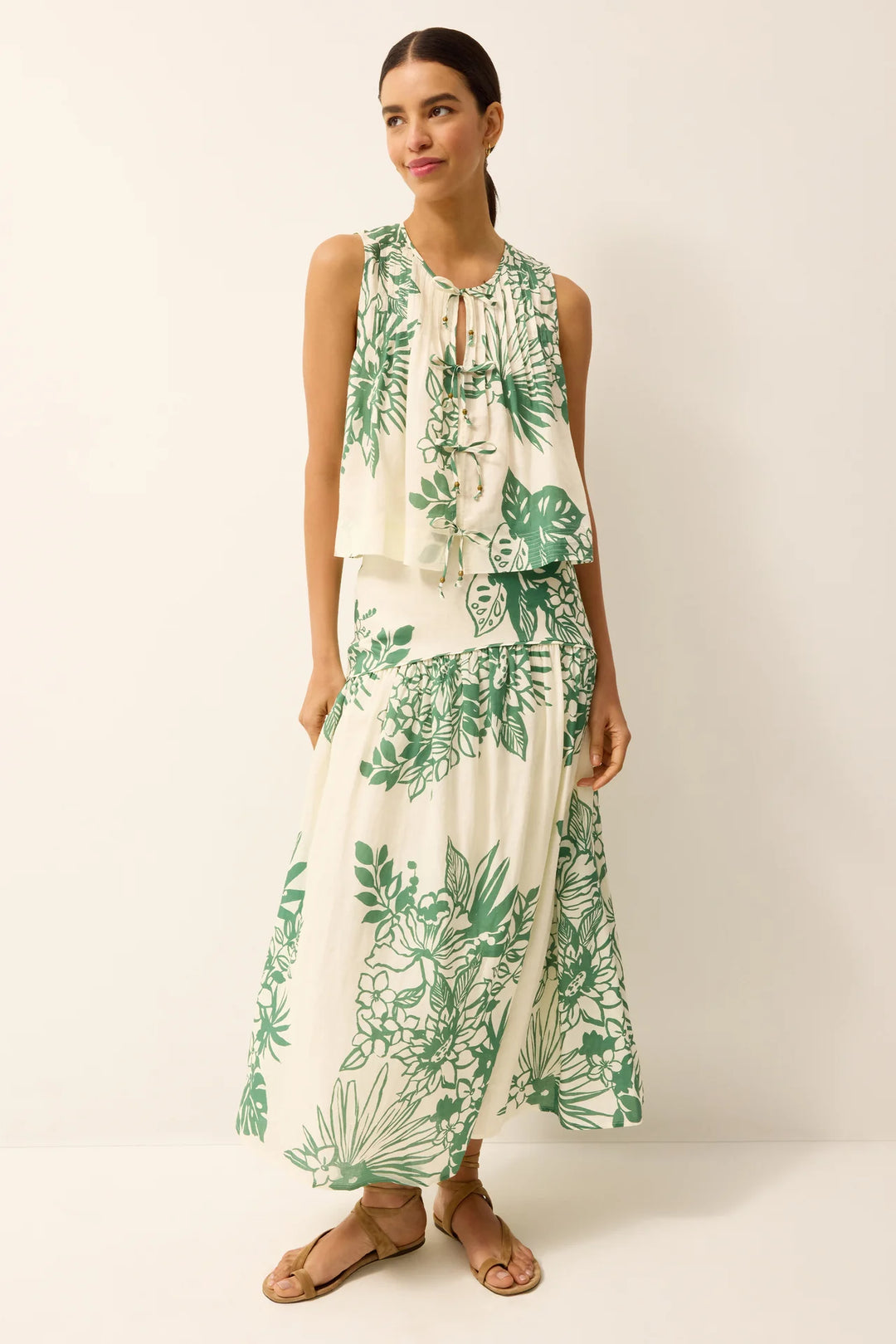 Marie Oliver Romina Top in green Garland print, A-line swing silhouette with front tie closures and round neckline, shown on model facing forward.