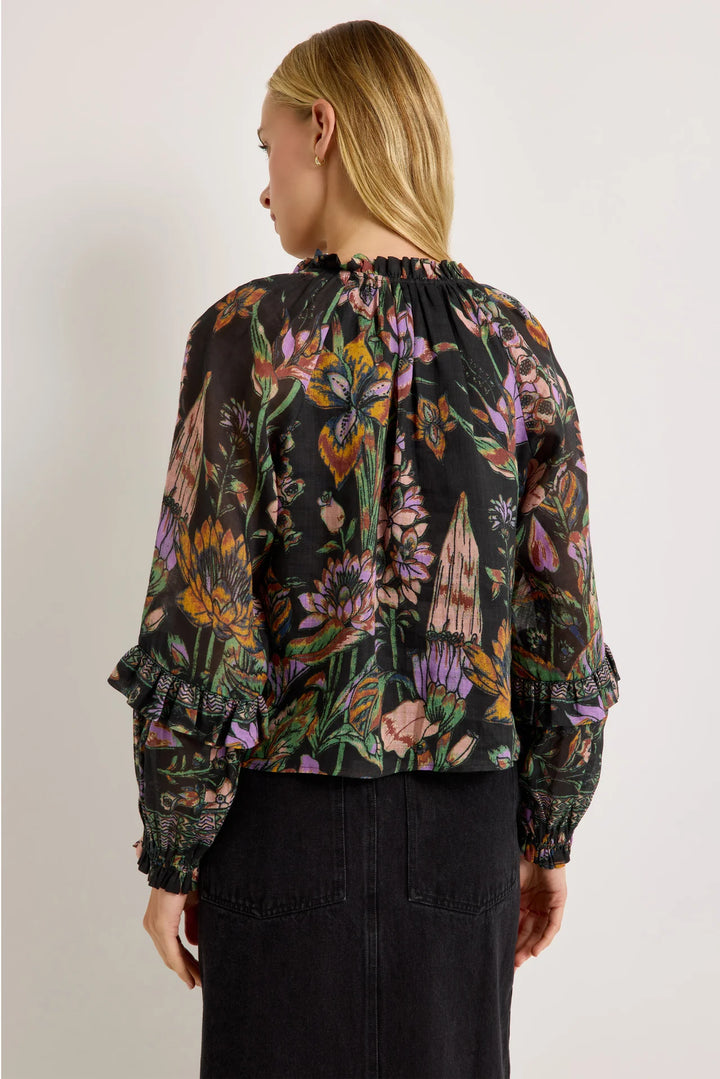 Marie Oliver Umika Top in Nightshade, back view on model, showing the gathered ruffle neckline, relaxed body, and sleeve ruffles with geometric border bands