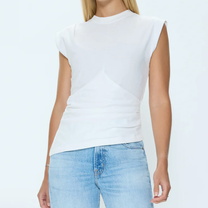 Person wearing a white sleeveless top and light blue jeans on a white background