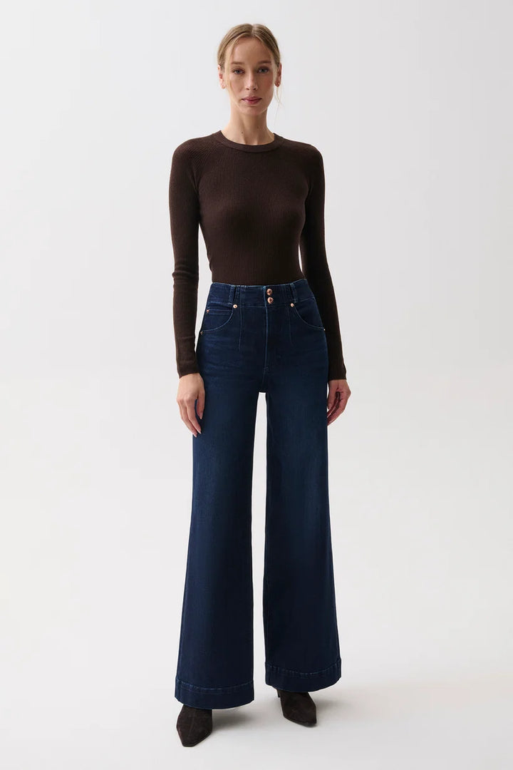 Front view, woman in brown ribbed sweater and Pistola Lana dark wash wide-leg jeans with double-button waist, standing.