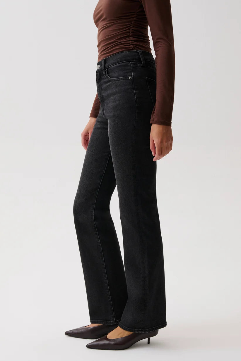 Pistola Evie High Rise Slim Boot in Jetset, full-length front view on model with arms raised, showing fitted hip, long inseam, and hem breaking at the heel.