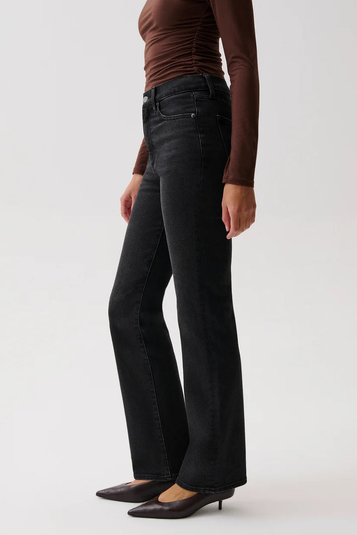 Pistola Evie High Rise Slim Boot in Jetset, full-length front view on model with arms raised, showing fitted hip, long inseam, and hem breaking at the heel.