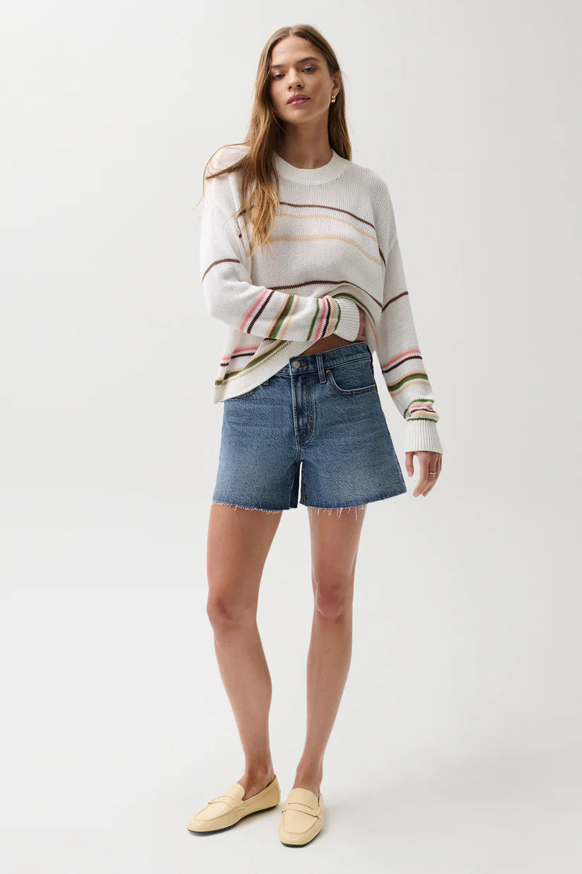 Pistola Kennedy Mid Rise Short in Cityscape, medium-wash denim, relaxed mid rise silhouette with raw-cut hem, full-length front view styled with striped knit sweater and loafers