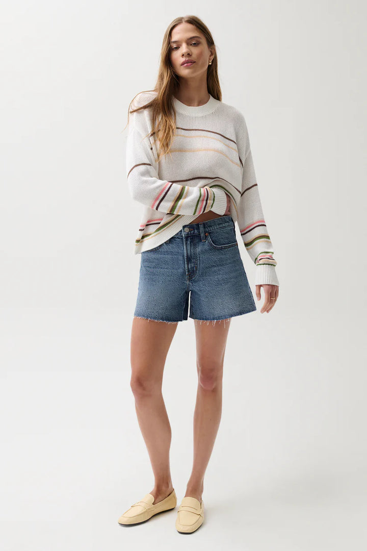 Pistola Kennedy Mid Rise Short in Cityscape, medium-wash denim, relaxed mid rise silhouette with raw-cut hem, full-length front view styled with striped knit sweater and loafers