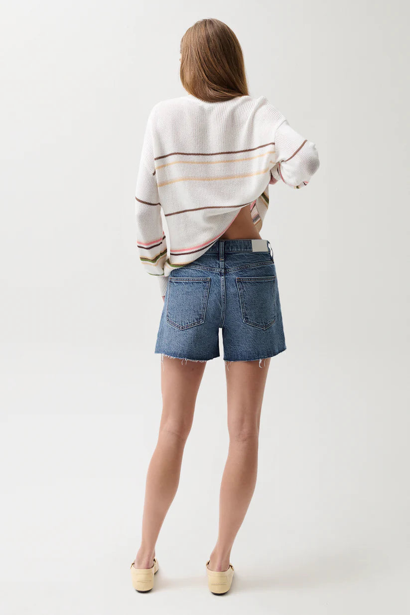 Pistola Kennedy Mid Rise Short in Cityscape, medium-wash denim, relaxed silhouette with raw-cut hem, back pocket detail, paired with striped knit sweater