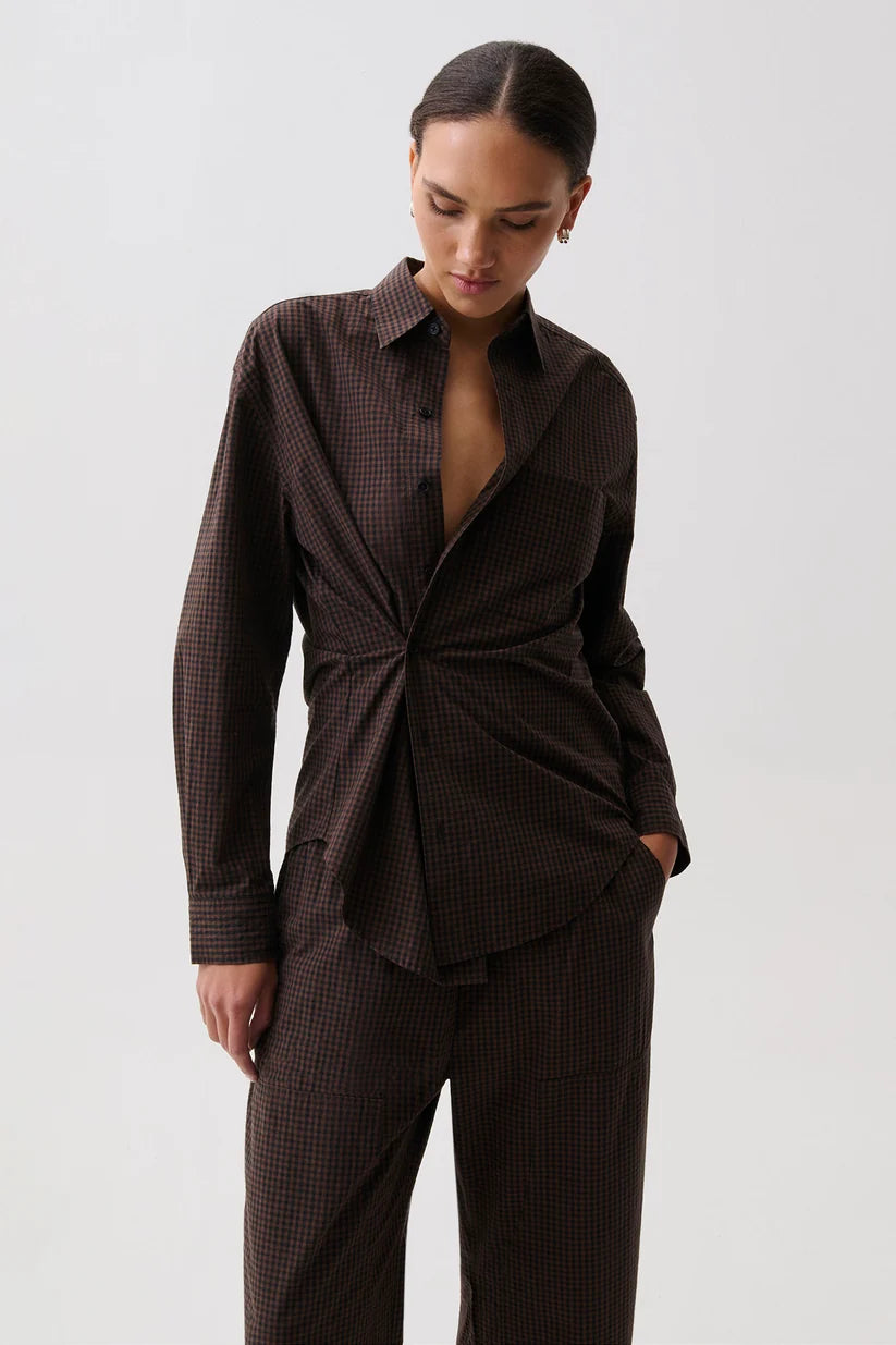 Pistola Mila Long Sleeve Button Down, front view, model wearing brown check wrap-front shirt with matching trousers, hand in pocket.