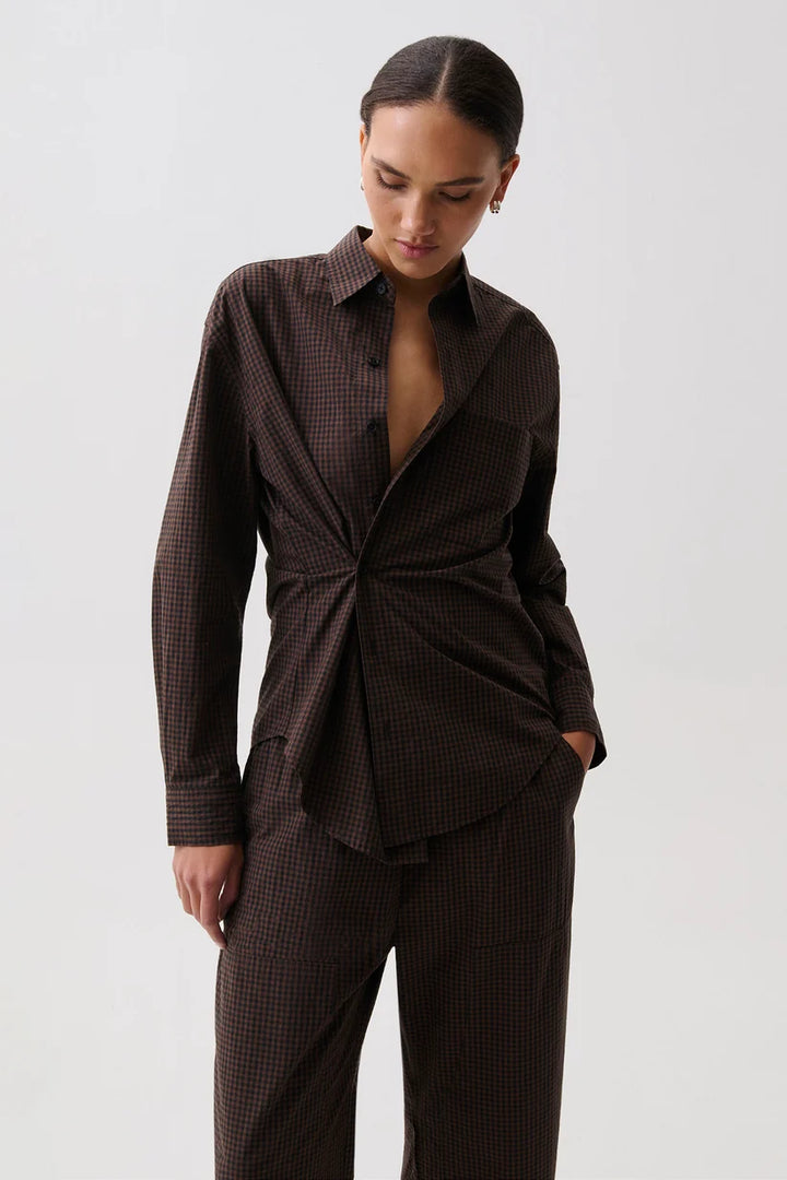 Pistola Mila Long Sleeve Button Down, front view, model wearing brown check wrap-front shirt with matching trousers, hand in pocket.