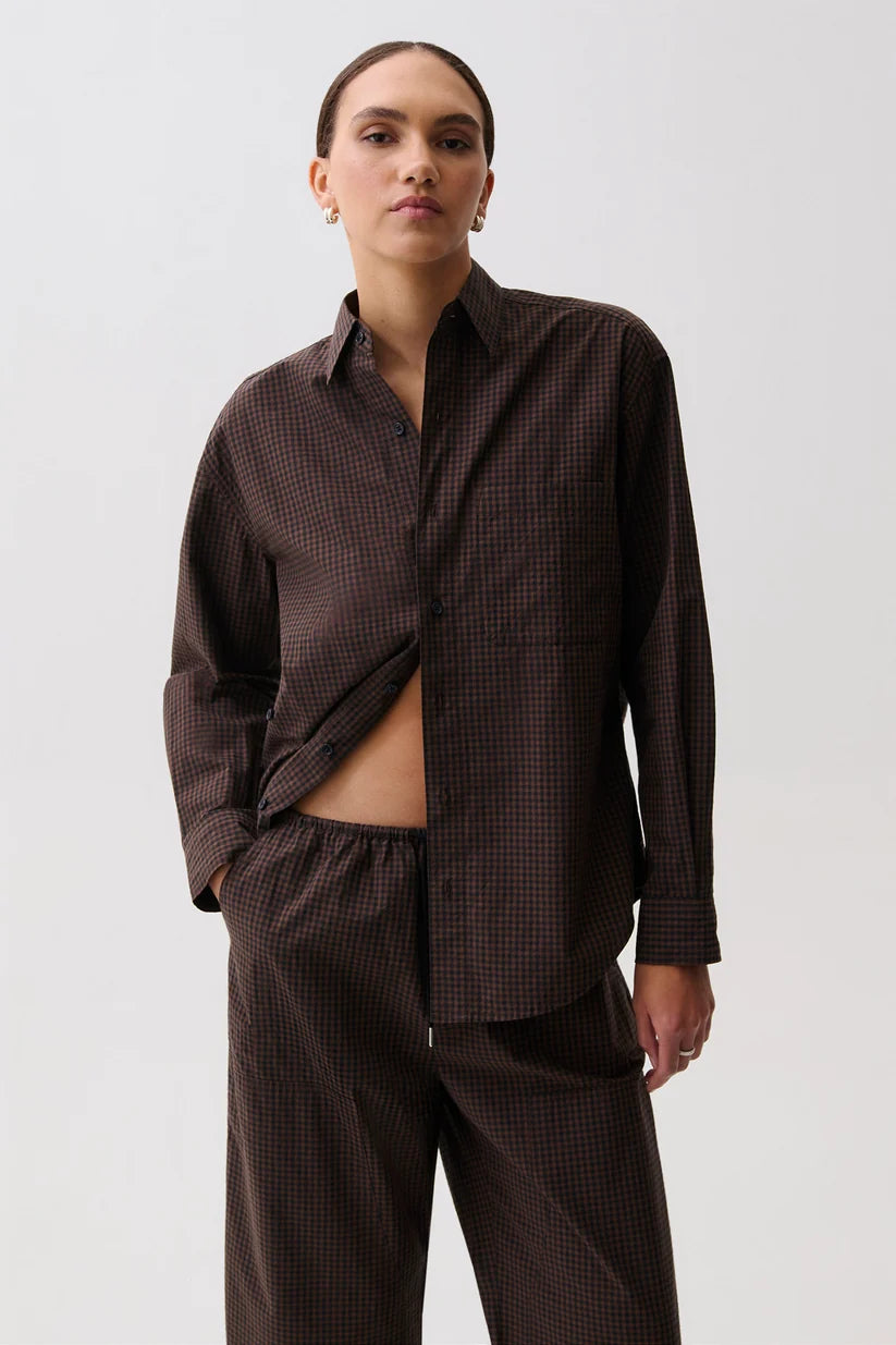 Pistola Mila Long Sleeve Button Down, front view, model wearing shirt with asymmetric hem and matching drawstring trousers.