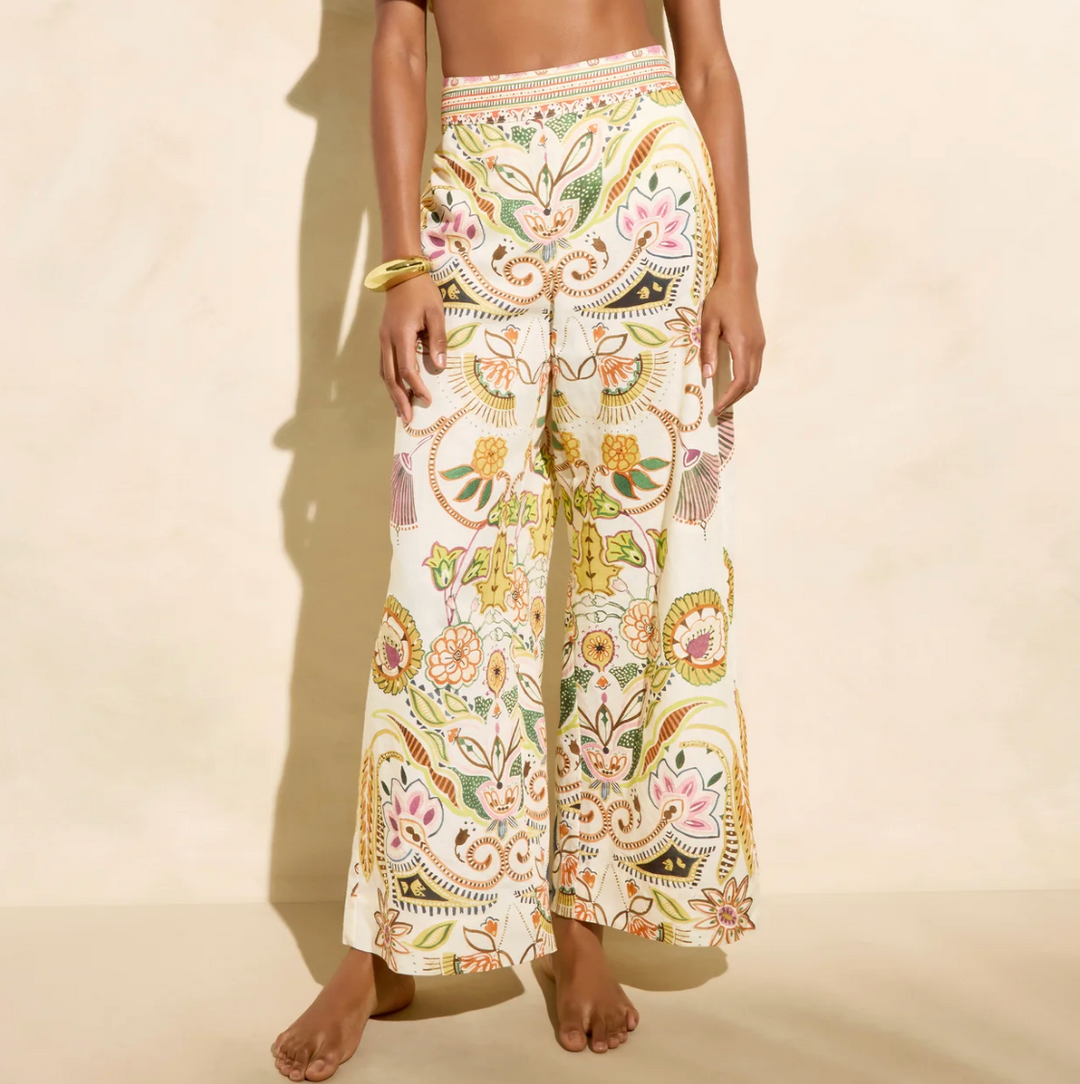 Person wearing a pair of patterned pants on a beige background
