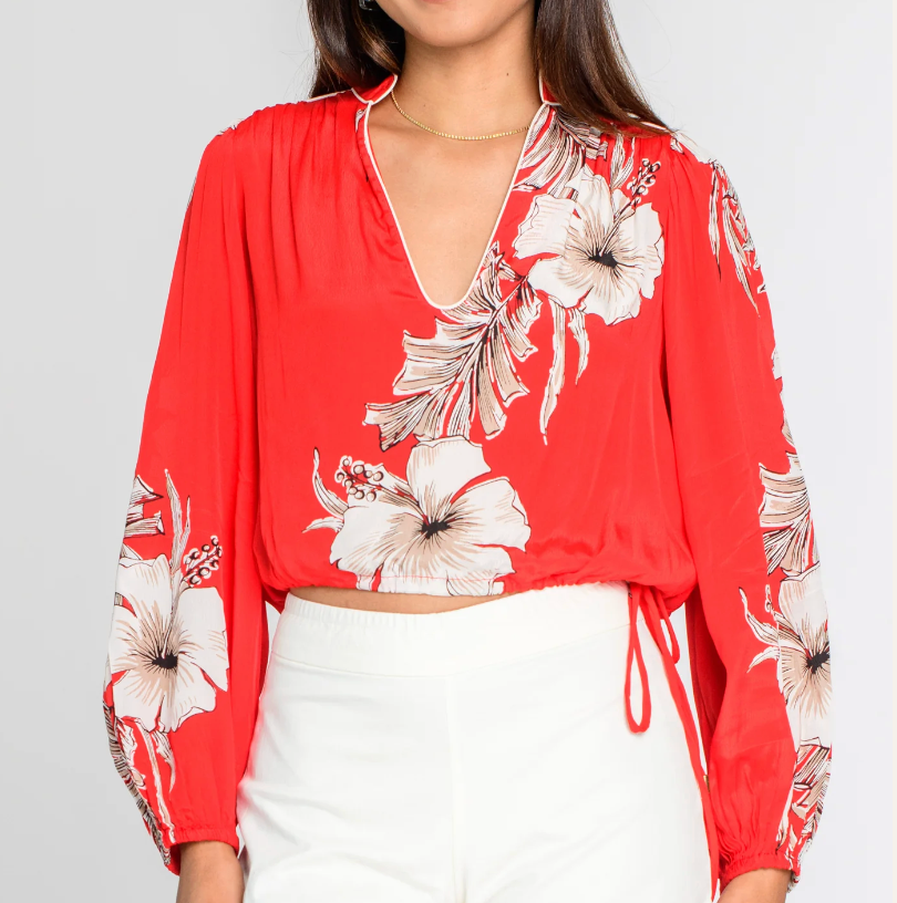 Red floral blouse worn by a person on a plain background