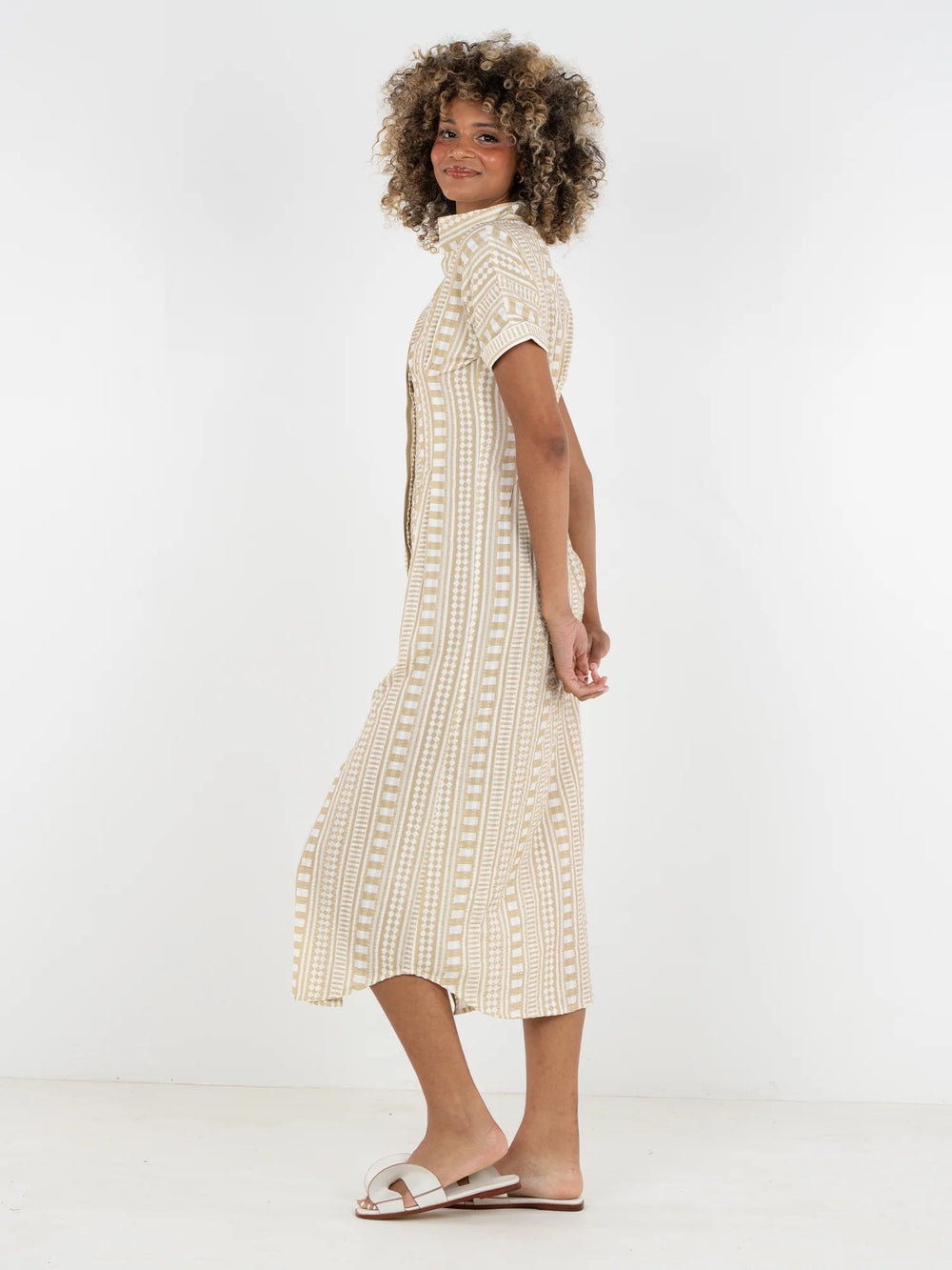 Side view of Emily McCarthy Georgia Dress in Piazza Stripe showing fitted waist, curved hem, and full midi skirt with movement.