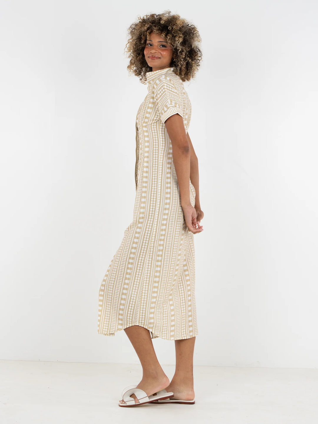 Side view of Emily McCarthy Georgia Dress in Piazza Stripe showing fitted waist, curved hem, and full midi skirt with movement.