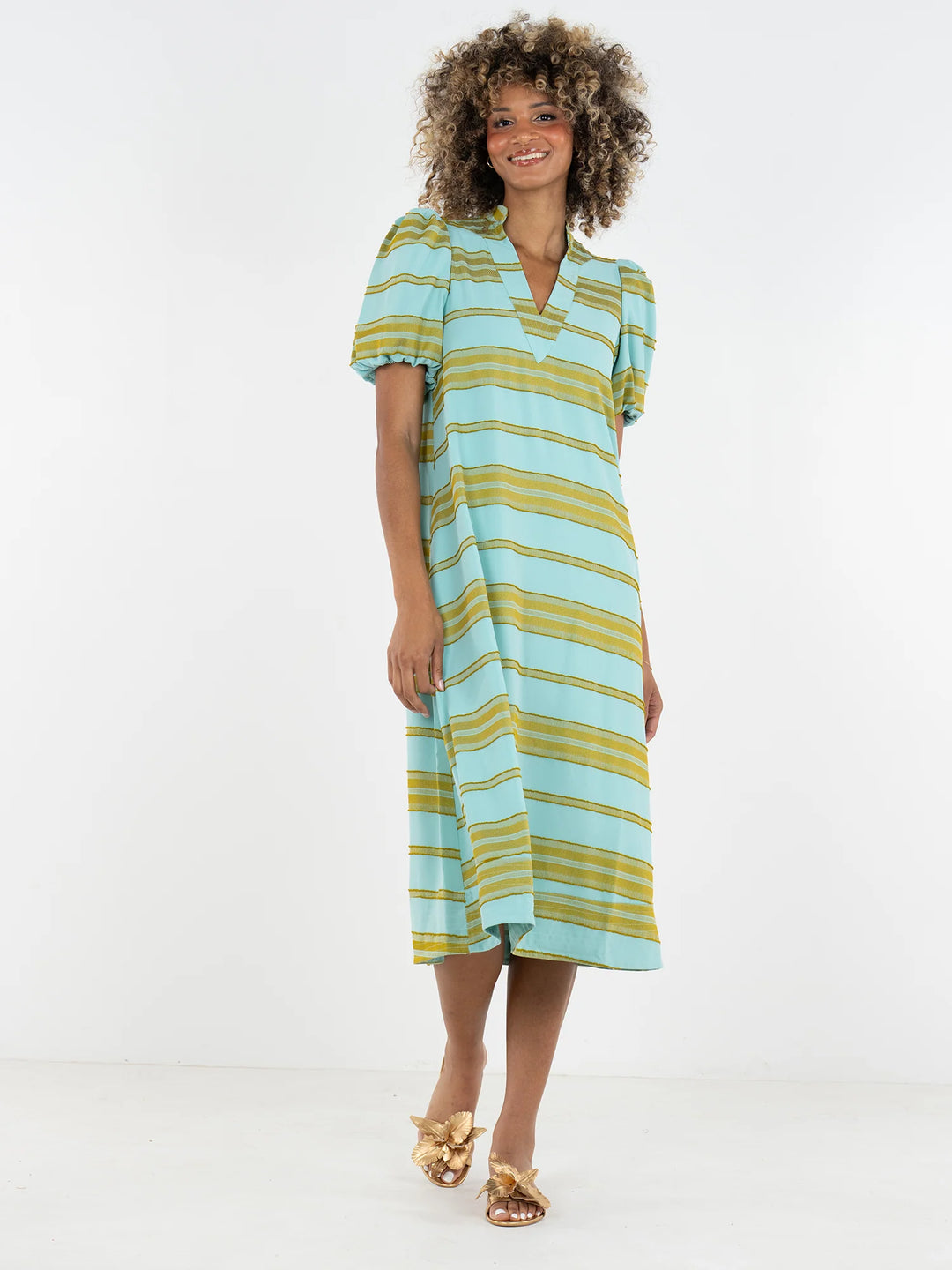 Emily McCarthy Hampton Dress in Fringe Stripe, aqua and chartreuse horizontal stripe midi with V-notch mandarin collar and elastic puff sleeves, shown on model with gold sandals.
