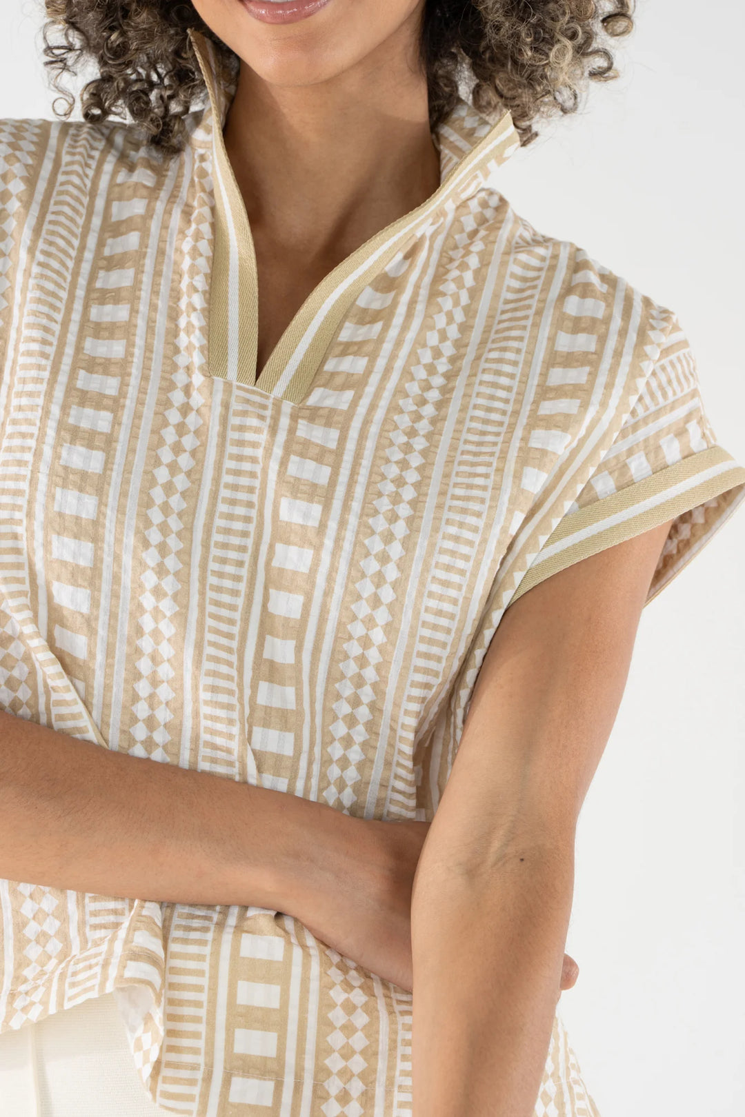 Close-up of Emily McCarthy Riviera Top showing Piazza Stripe geometric print with diamond, check, and linear motifs on textured cotton ground with tonal trim at neckline.