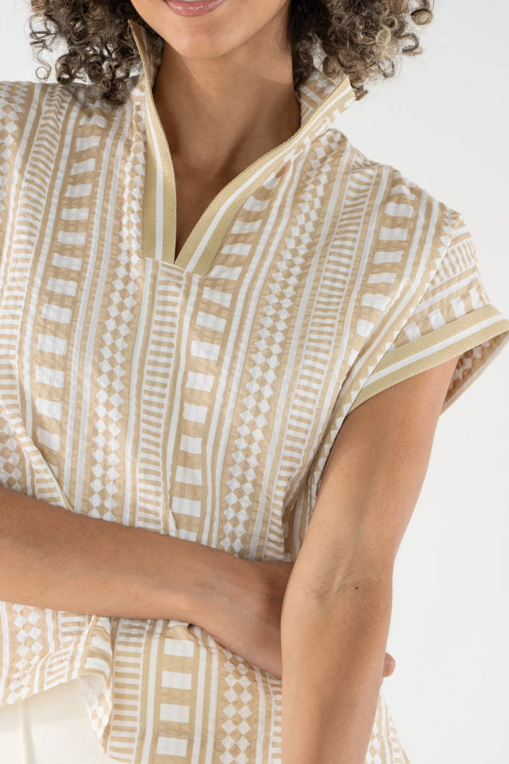 Close-up of Emily McCarthy Riviera Top showing Piazza Stripe geometric print with diamond, check, and linear motifs on textured cotton ground with tonal trim at neckline.