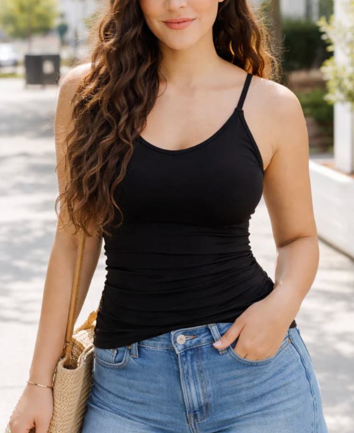 Elietian Built-In-Bra Cami in black with V-neckline and adjustable straps, shown layered under an open-knit cardigan with light-wash jeans.