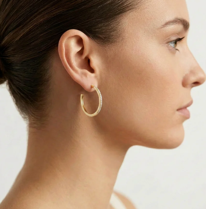 Ella Stein A Hoop Thing Medium Hoop Earrings in gold — side profile on model showing hoop scale at ear, smooth inner arc, and pavé diamond detail catching light.