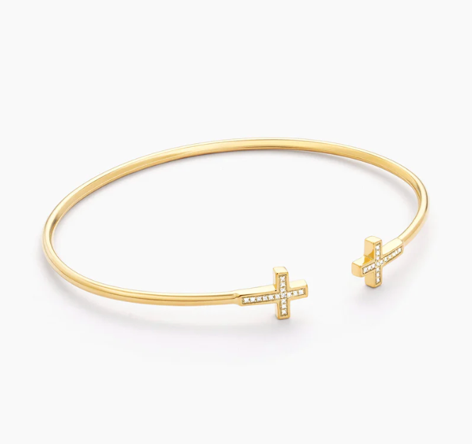 Ella Stein Cross Flexi Cuff Bracelet in gold — angled flat lay showing dimensional cross terminal construction, raised frame detail, and flexible open cuff profile.