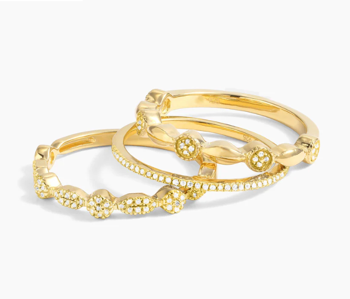 Ella Stein Shiny Three Stackable Ring Set in gold — angled flat lay of two rings stacked showing pavé cluster roundel band and mixed bezel geometric link band in gold plating.
