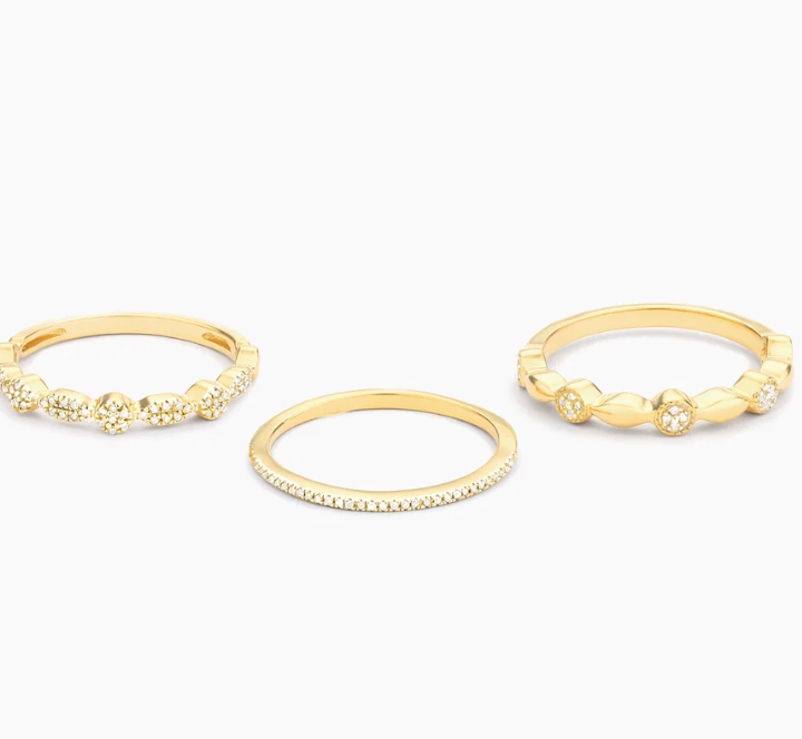 Ella Stein Shiny Three Stackable Ring Set in gold — flat lay of all three bands separated showing individual designs: slim pavé half-eternity, pavé cluster roundel, and mixed bezel geometric link band.