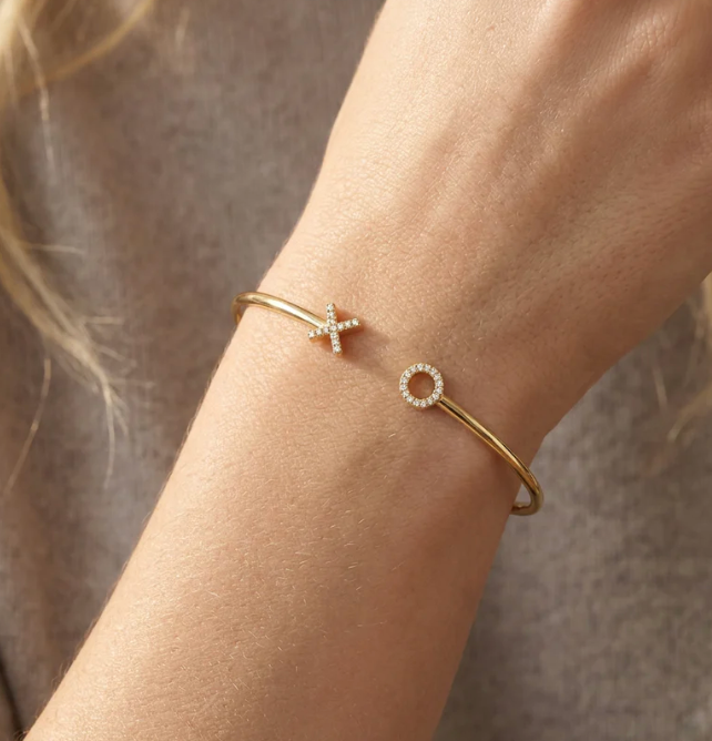 Ella Stein XO Flexi Cuff Bracelet in gold — on-model wrist shot showing X and O terminal scale, pavé diamond detail, and slim wire cuff fit in gold plating.