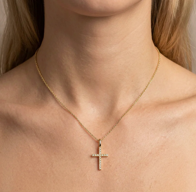 Ella Stein Believe Cross Pendant Necklace in gold, diamond pavé cross pendant worn at collarbone on model, close-up neck view.
