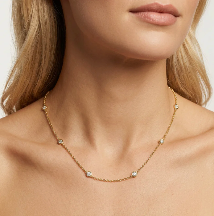Ella Stein In The Loop Chain Necklace in gold, bezel-set diamond stations worn at collarbone on model, close-up neck and décolletage view.