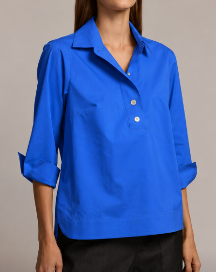 Hinson Wu 3/4 Sleeve Aileen Top in cobalt blue stretch cotton, styled with an open placket and two oversized buttons below a point collar, worn with black trousers.