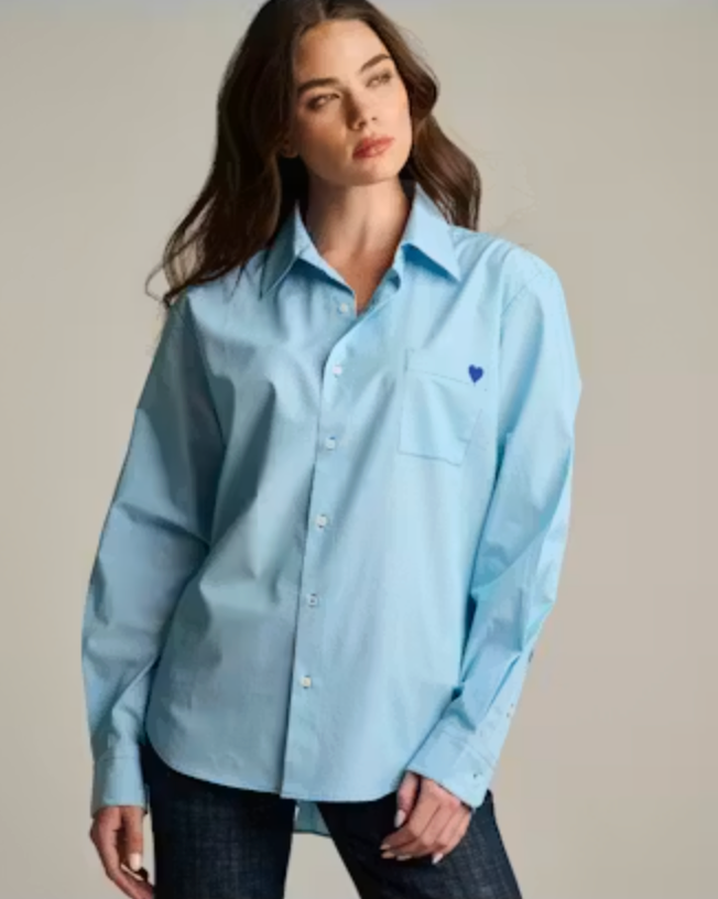 Front on-model — Lisa Todd Stripe It To Me Shirt in blue fine stripe, oversized button-down with point collar and chest pocket, worn open over dark denim