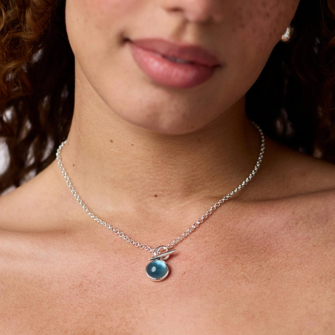 Julie Vos Solara Solitaire Necklace in silver plate with iridescent Montana Blue cabochon pendant on a rolo chain on model