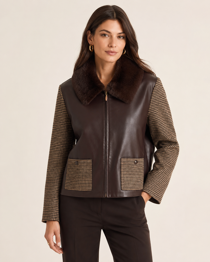 Tyler Boe Lucy Mixed Media Jacket in Dark Brown, front view, model wearing brown vegan leather jacket with houndstooth sleeves, fur collar, and dark trousers.