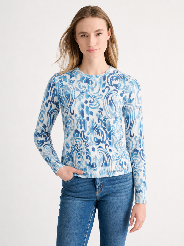 Woman wearing a blue and cream paisley print cotton crewneck sweater with jeans.
