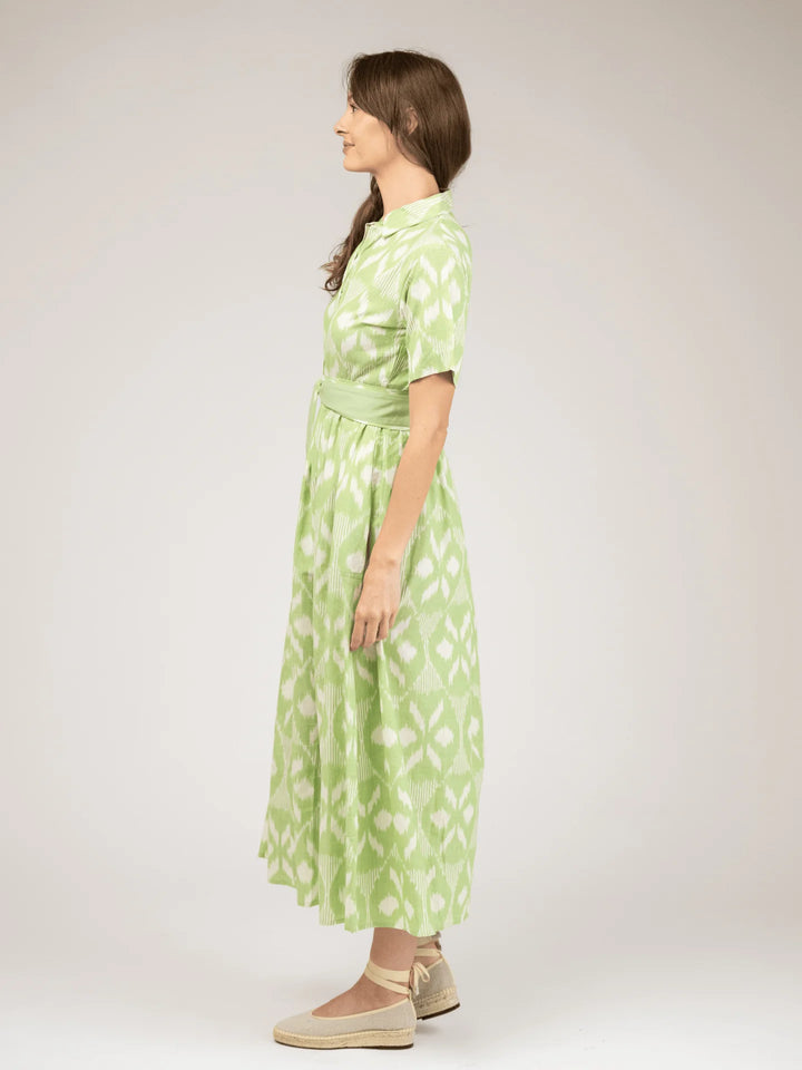 Beau &amp; Ro Elle Maxi Dress in Lime Ikat — side profile view showing A-line skirt volume, tie belt drape at waist, and shirt collar detail; full-length silhouette with espadrille styling.