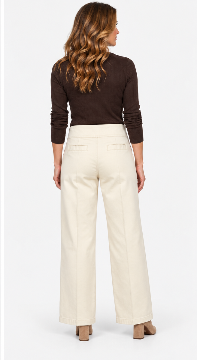 Elliott Lauren Wide Leg Pant in Cream, full-length back view on model with hand in pocket, showing high contoured waistband, seamed front creases, angled pockets, and full wide leg over taupe suede booties, paired with a brown ribbed sweater.