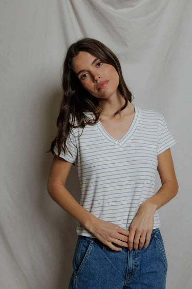 Close-up of woman wearing white and blue stripe brushed knit v-neck tee, neckline and fabric texture visible, hands relaxed at waist — perfectwhitetee Elliot Brushed V-Neck Sweater Tee