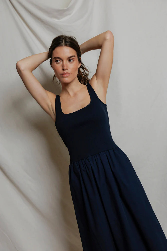Image of model in Fabiola Cotton Poplin Sleeveless Dress in Navy by perfectwhitetee facing front with arms up.