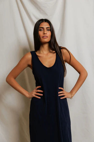 Close-up of woman wearing navy Supima cotton tank dress, wide strap and deep scoop neckline detail visible, gold bracelet at wrist — perfectwhitetee Jasmine Sleeveless Dress
