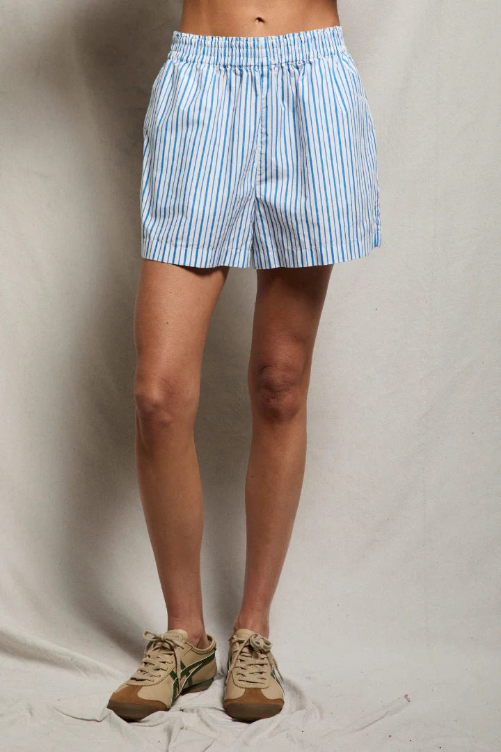 Close-up of blue and white vertical stripe cotton poplin shorts with smocked elastic waistband and side pocket, hand in pocket — perfectwhitetee Julie Short in Pacific Blue Stripe