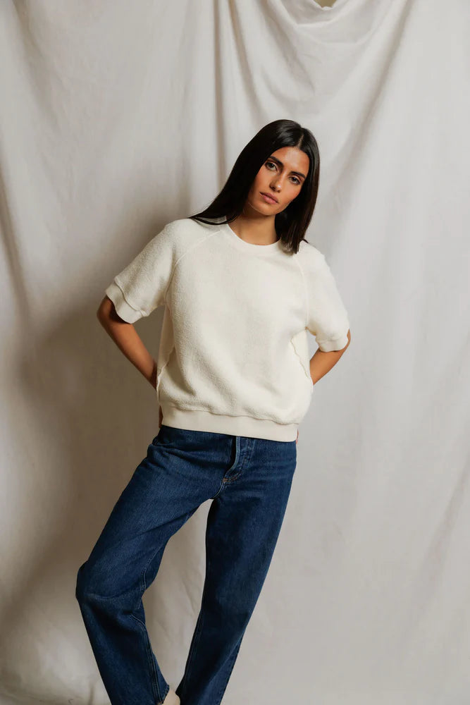 This Kennedy Sweatshirt by perfectwhitetee carries the signature fleece feel into a short-sleeve silhouette — raglan sleeves, a crew neckline, and a relaxed body - shown on model with jeans on front side.