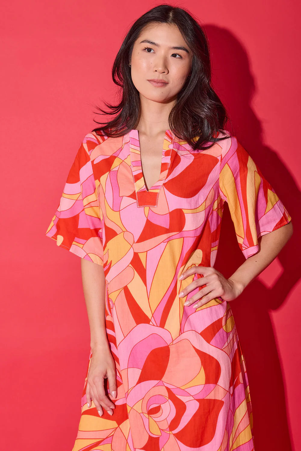 Closeup of the Alden Adair Delaney Dress in Moroccan Poppy print, showing the notched V-neckline and flutter sleeves.