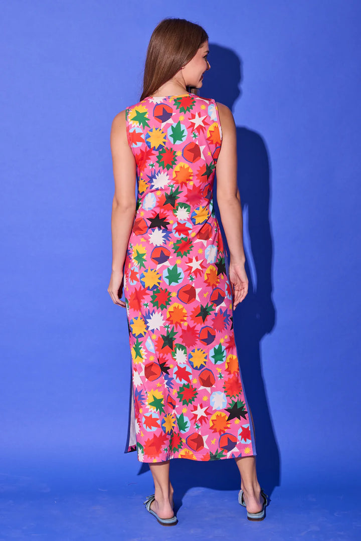 Alden Adair Berkley Maxi Dress, back view in hot pink rainbow starburst print, showing the sleeveless crew-neck cut and straight column maxi shape.