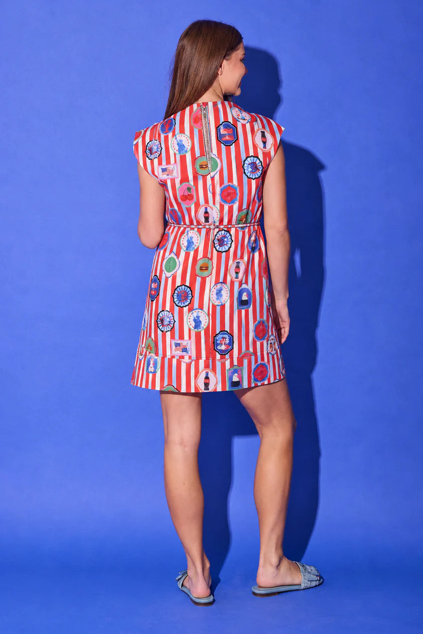 Alden Adair Leigh Dress, back view in red-and-white stripe with Americana icon print, showing the cap sleeves, back keyhole at the neck, tie-waist, and banded A-line hem above the knee.