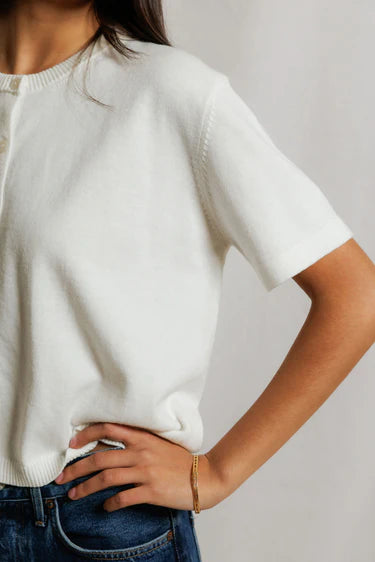 Close-up of white cotton knit cardigan showing ribbed cuff, button placket detail, and sweater knit texture, gold bracelet and ring at wrist — perfectwhitetee Maude Short Sleeve Cardigan