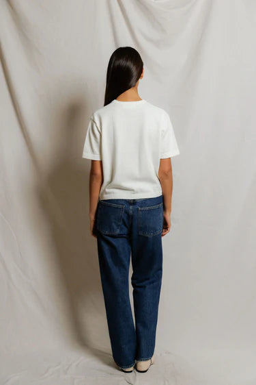 Back view of white cropped cotton short sleeve cardigan showing boxy silhouette and ribbed hem, paired with dark wash wide-leg denim and ivory flats — perfectwhitetee Maude Cotton Cardigan in White