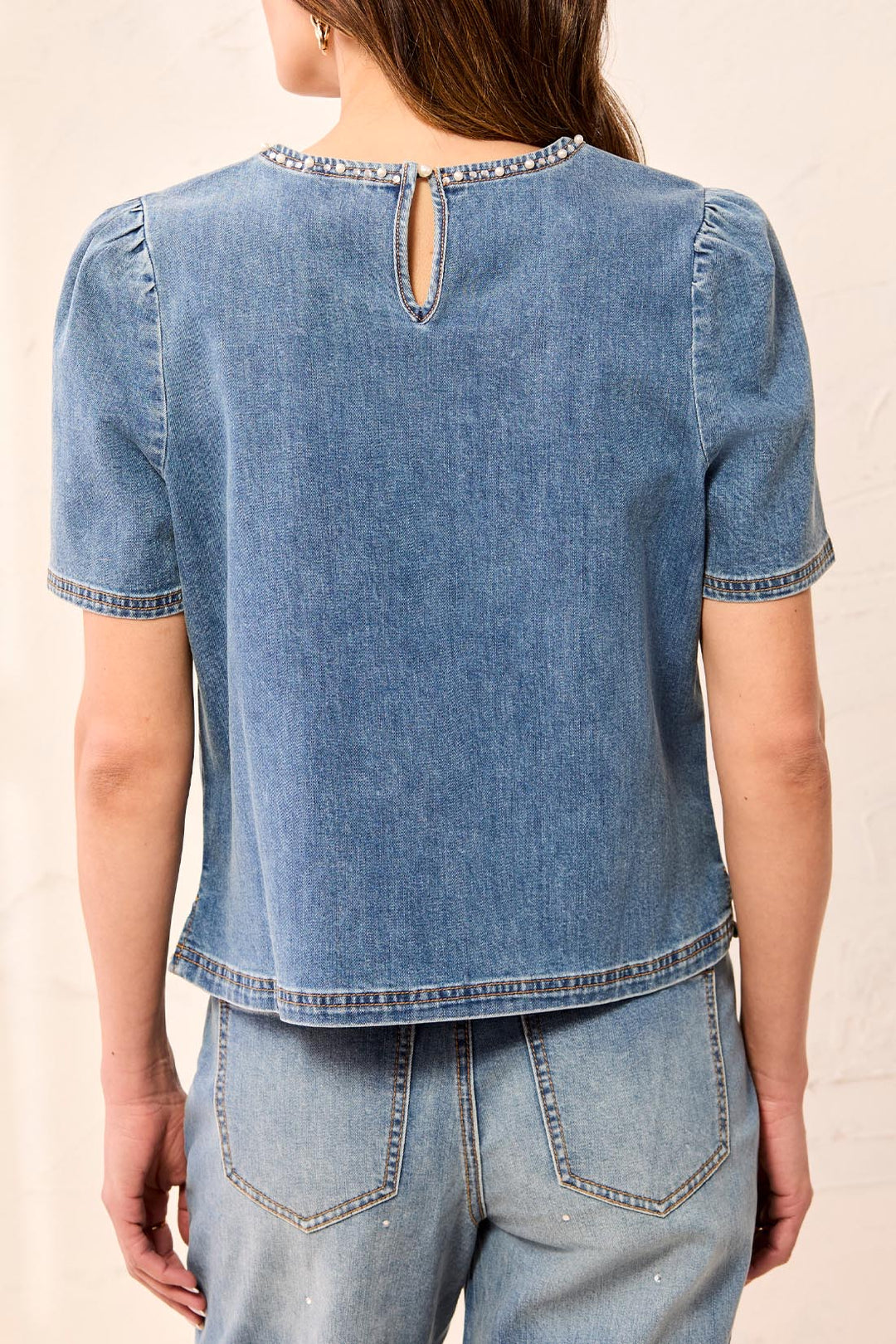 Tribal Denim T-Blouse with Pearls &amp; Stones in Stargazer, back view on model, showing keyhole button closure, pearl-trimmed neckline, gathered shoulders, and side-slit hem.