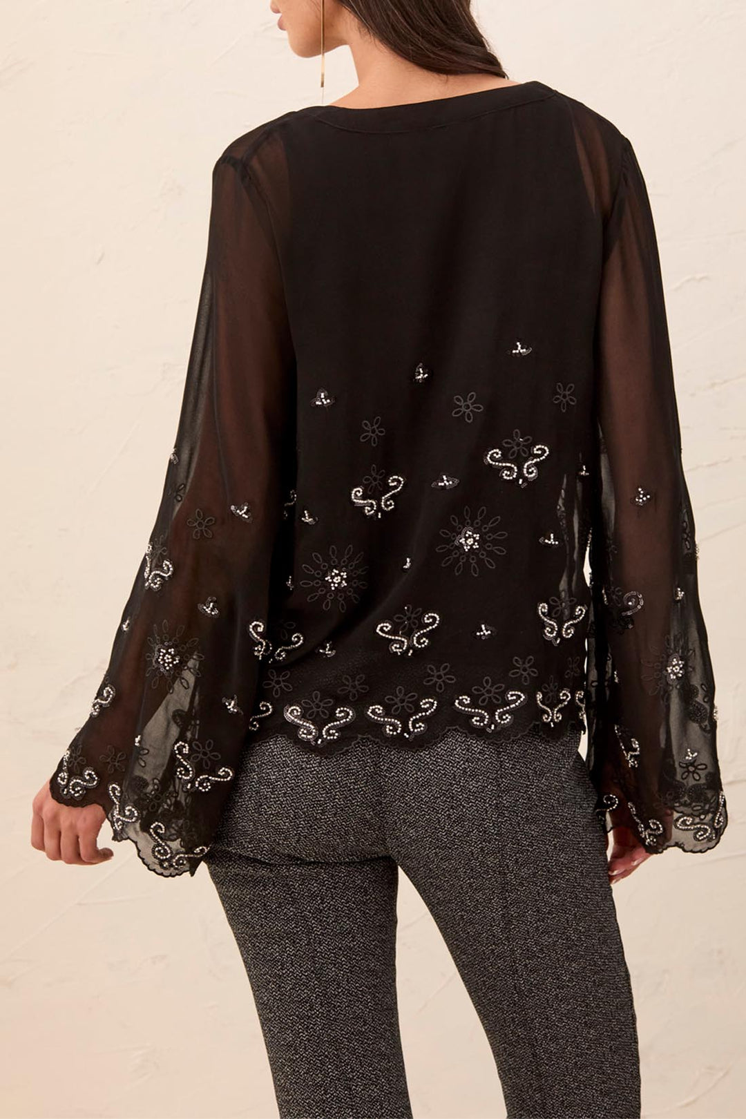 Tribal Long Bell Sleeve Blouse, back view on model, shown in black with sheer shoulders and sleeves, scattered beaded motifs, and scalloped embroidered hem.