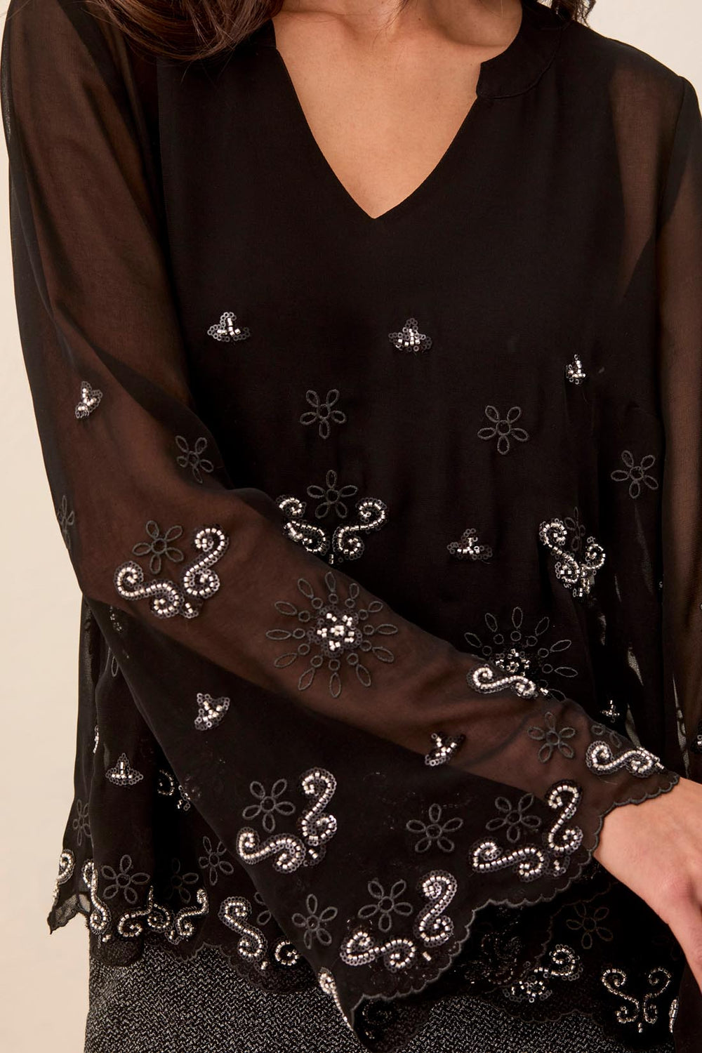 Tribal Long Bell Sleeve Blouse, close-up of embroidered florals and sequined, beaded scrollwork on the body and sheer sleeve, with scalloped cuff edge.