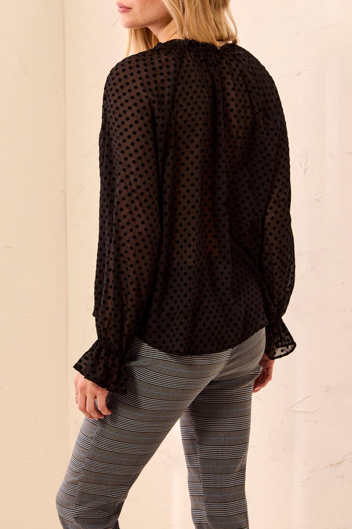 Tribal Long Sleeve Button Front Blouse with Tie in Black, back view on model, showing gathered raglan shoulders, blouson sleeves with ruffled elastic cuffs, and sheer dotted fabric.