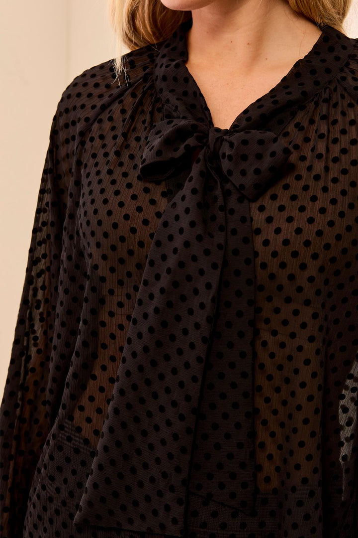 Tribal Long Sleeve Button Front Blouse with Tie in Black, close-up of the tied bow at the neckline and flocked velvet dots on sheer crinkled chiffon.