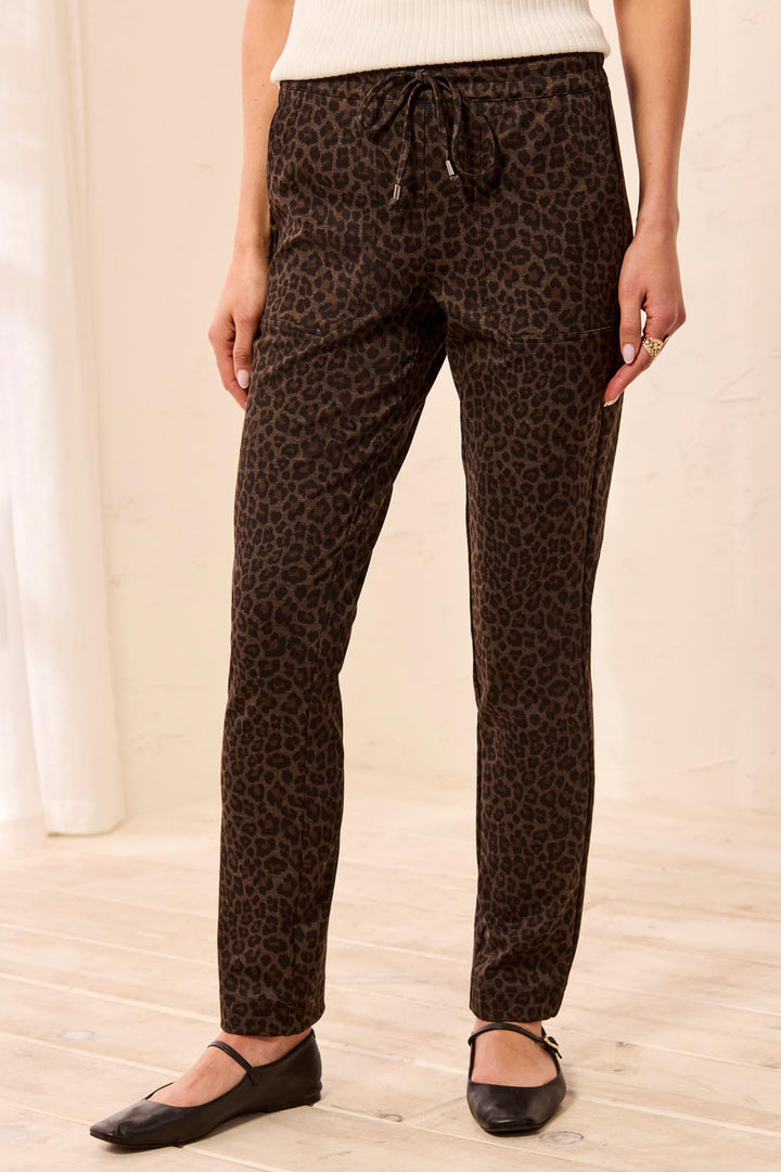 Tribal Pull On Ankle Pant with Pockets in Hickory, front view on model, showing leopard print, elastic drawcord waist with metal-tipped ties, front patch pockets, and slim tapered ankle-length leg.